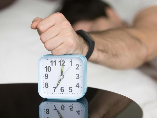 a_man_snoozing_an_alarn_clock