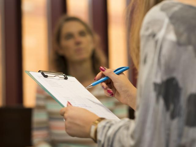 Person making notes on a clipboard