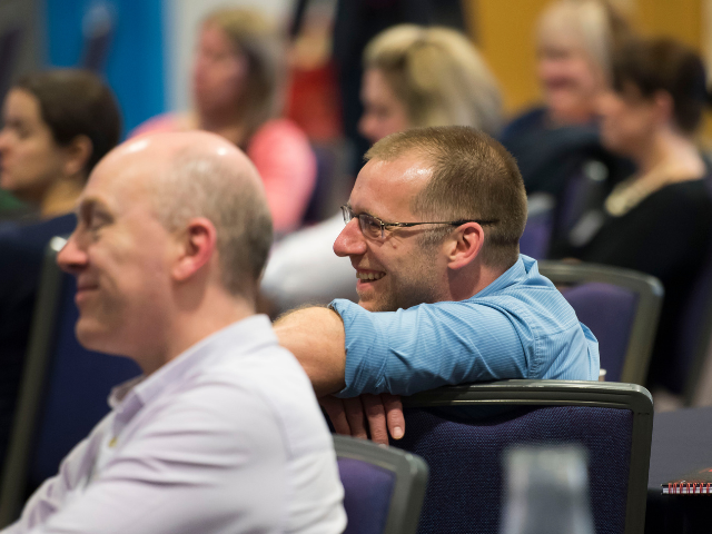 Men sat in audience smiling