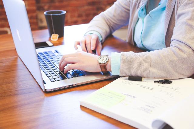 Person sitting at desk working on a laptop