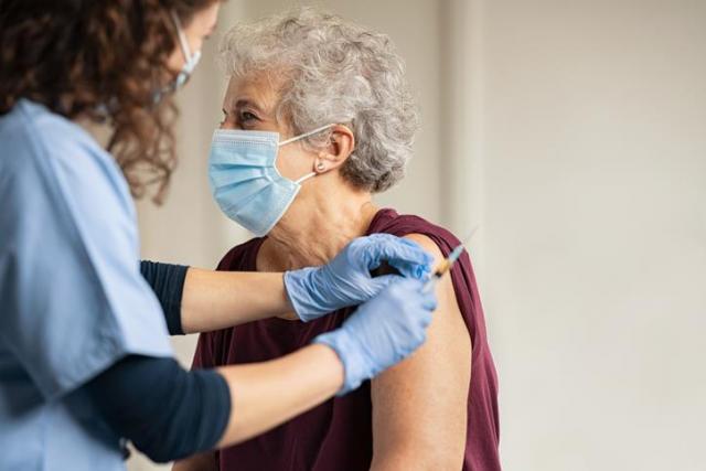 Nurse giving female patient a vaccination