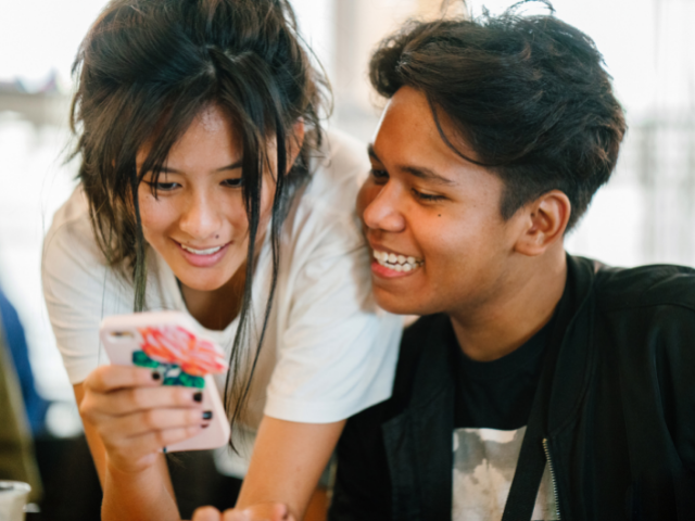 Two young people looking at a phone