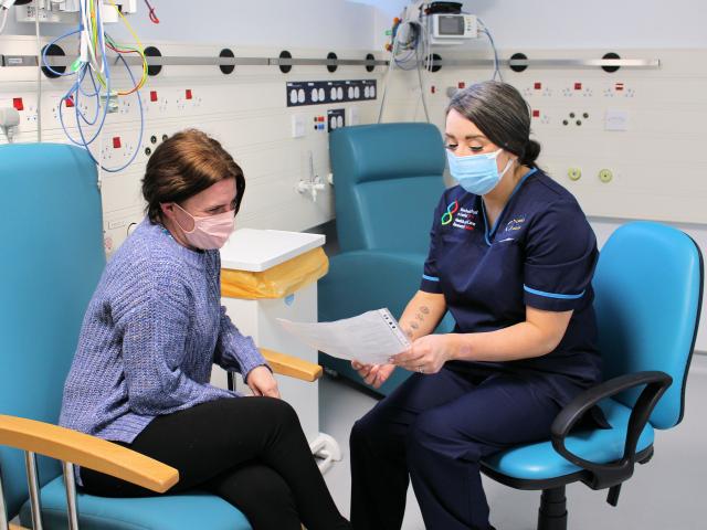 Anna Roynon wearing face mask chatting to a patient