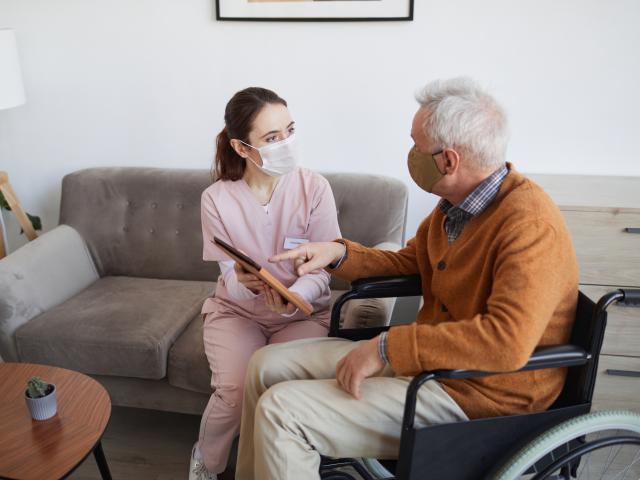 Care home worker speaking to elderly gentleman