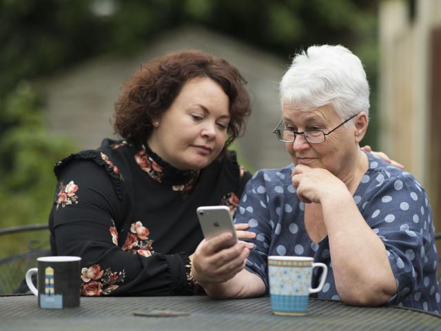 Two people helping with research through a phone
