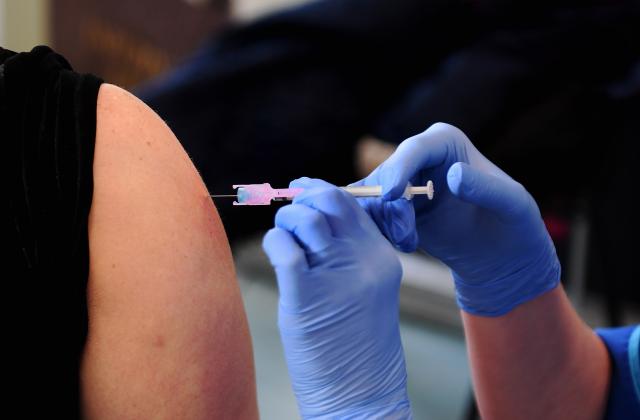 Close up of patient receiving vaccination at top of arm
