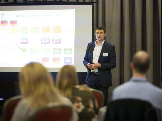 Man giving presentation to a crowd during an event workshop