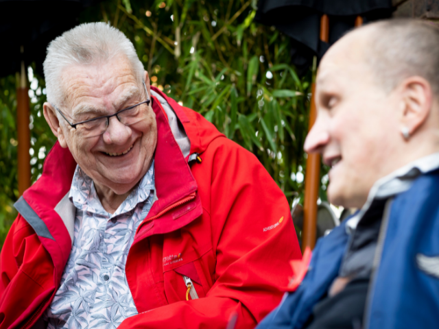 Two older men sitting together outside