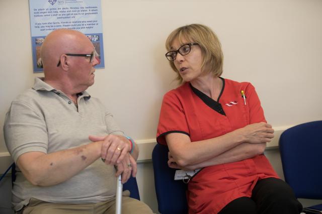 Member of hospital staff talking to a patient