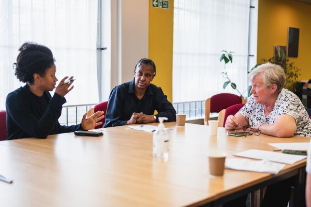 Three women sat a round a table talking