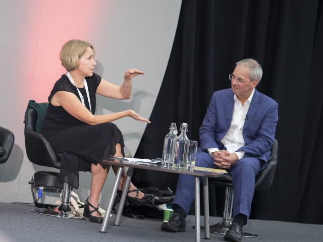 Two people on stage at a conference