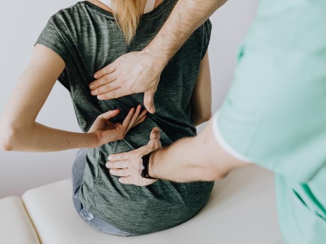 Women and physio therapist looking at spine