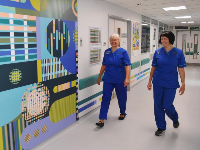 Two research nurses walking down a hospital corridor