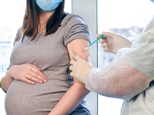 A pregnant woman getting a vaccine. 