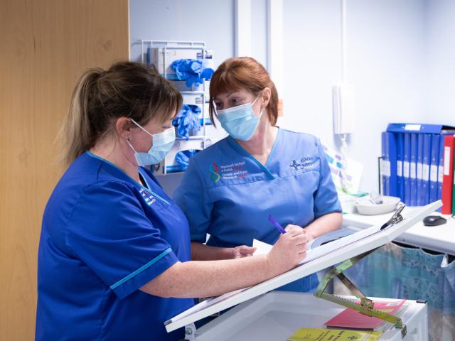 Two nurses looking at a patient chart