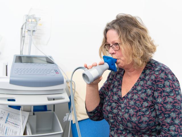 Woman using device to test lung strength