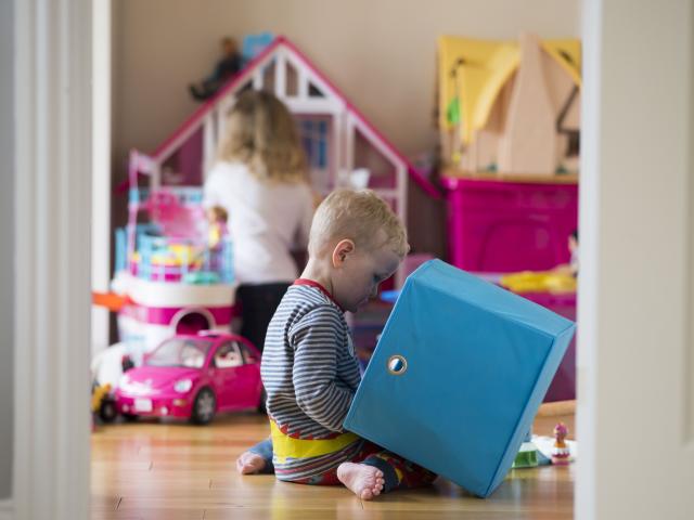 A little boy and a little girl playing in the playroom.