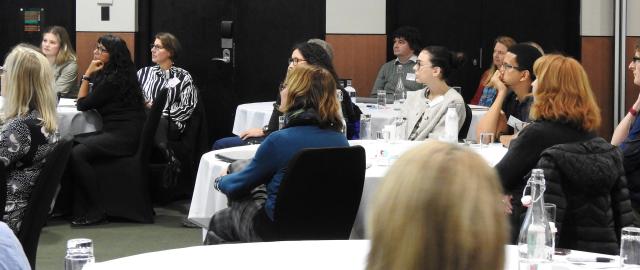 People in room looking at speaker