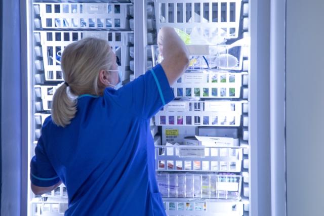 A nurse checking equipment in a lab