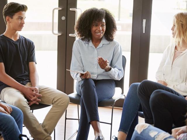 People of mixed ethnicities sitting around a table in a library