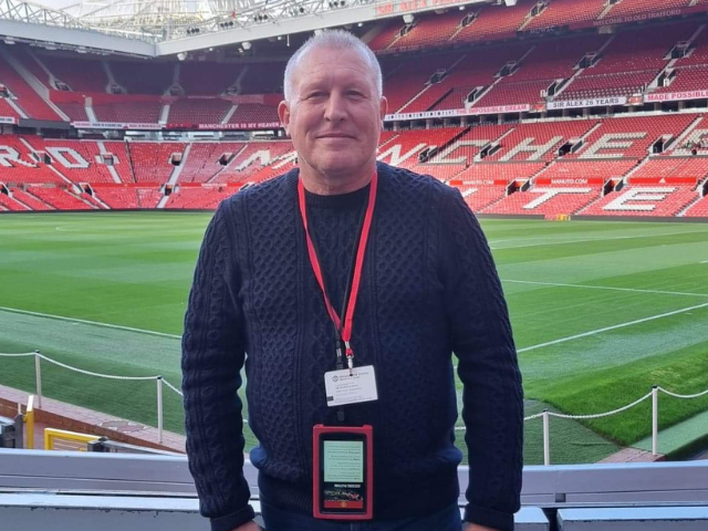 A photo of Craig posing at the football stadium. 