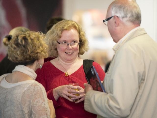 Three people talking at an event
