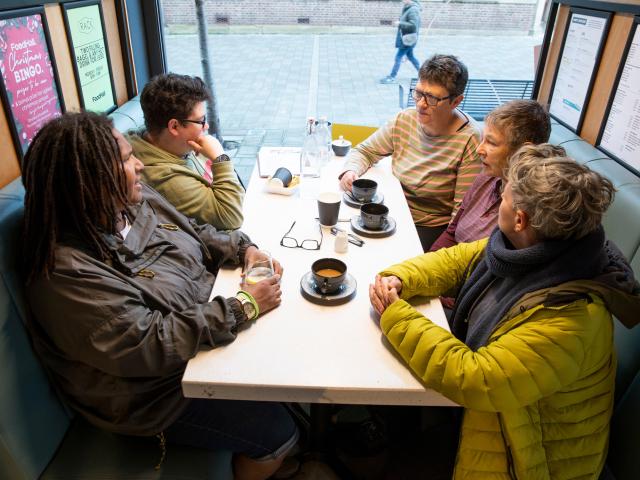 People sat at a table having a coffee