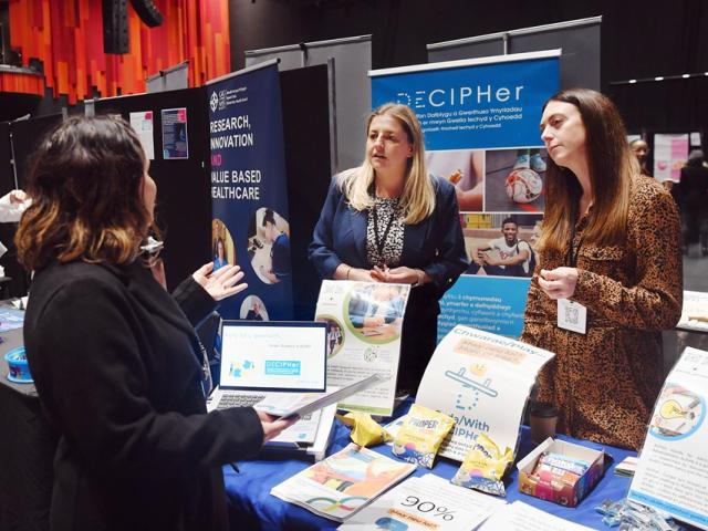 people chatting at a conference exhibit