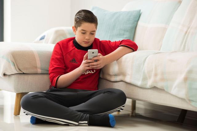 a boy using a mobile phone