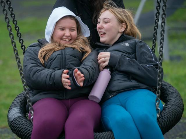 young people playing on a swing