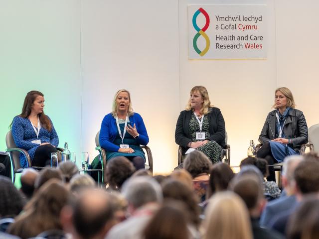 Group of four women sat on chairs on a stage