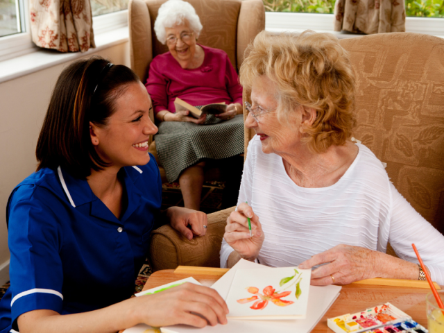 Care home nurse with two female residents. 