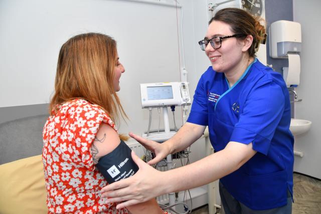 a research nurse checking a woman's blood pressure