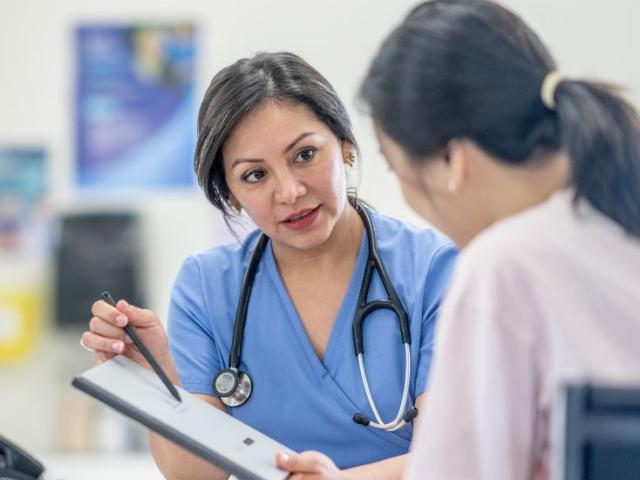 a_female_clinician_talks_to_a_woman