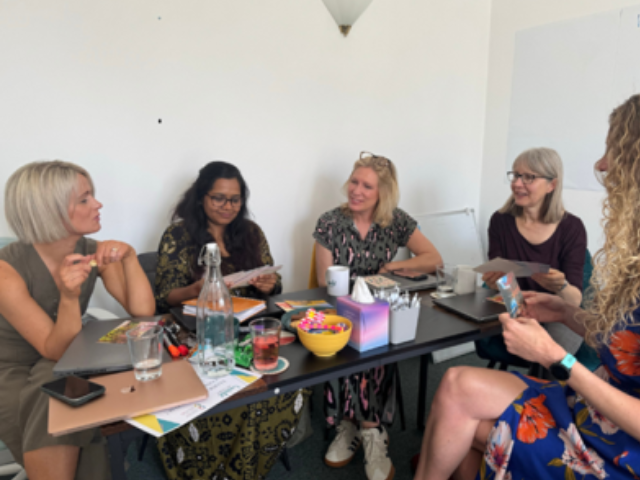 5 women sat around a table at an event