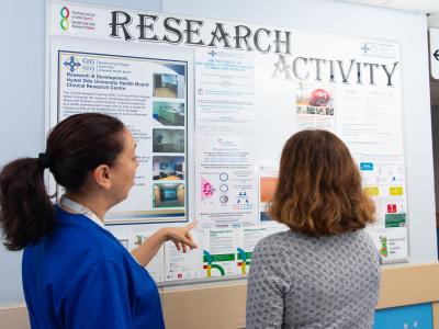 two researchers looking at a research activity board