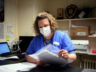 Nurse reading documents wearing a face mask