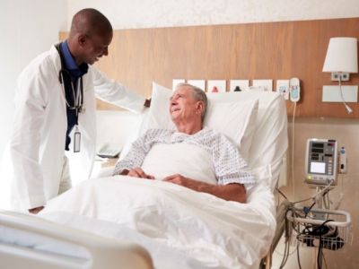 A man on a hospital bed talking to a doctor. 