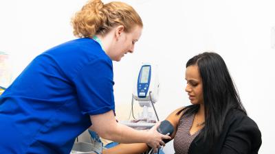 a nurse measuring blood pressure for a woman