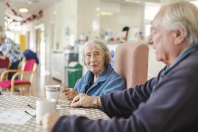 two older people chatting at a table