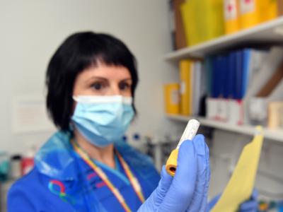 Research nurse looking a sample in a vial