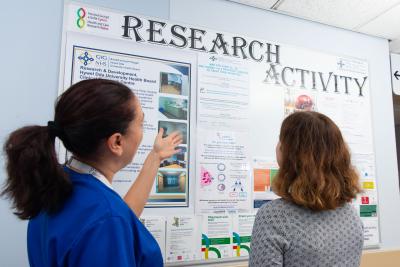 two women looking at a research activity board