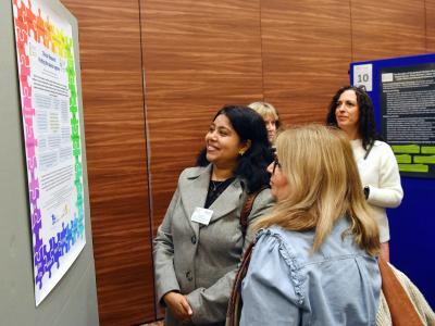 Conference attendees marveling at a poster displayed on the poster board. 