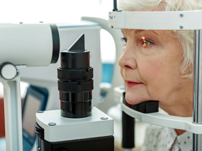 An elderly woman getting an eye test. 