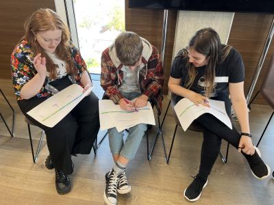Three young people completing forms