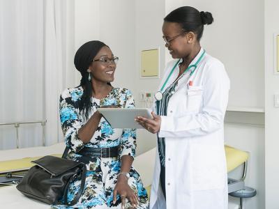 A black female doctor with a patient. 