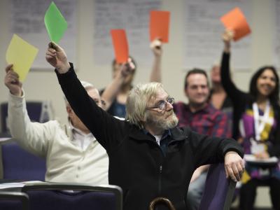 People holding up cards to give feedback