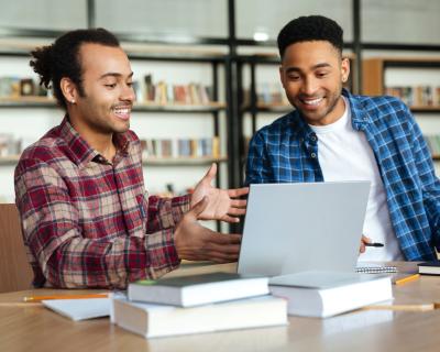 two men looking at a laptop