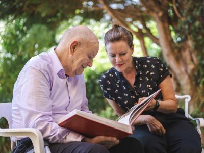 A woman caring for an elderly gentleman. 