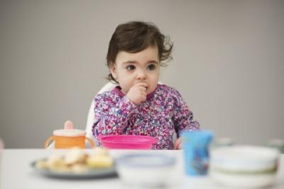 Baby girl eating in high chair